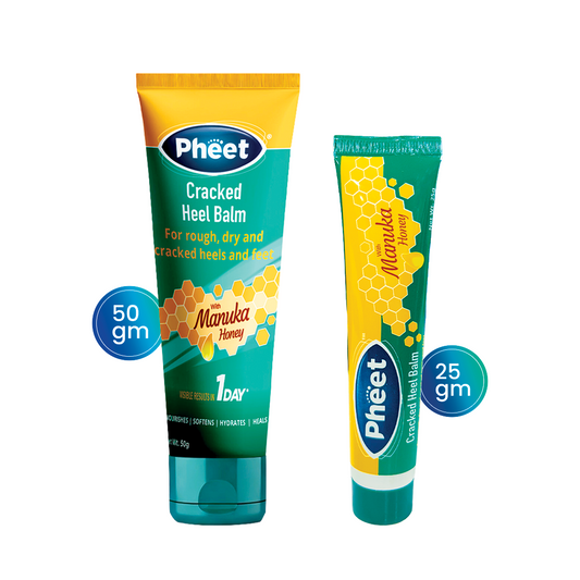 Two tubes of Pheet Cracked Heel Balm with Manuka Honey in 50g and 25g sizes. The packaging is teal and yellow with a honeycomb graphic, highlighting benefits like nourishing, softening, hydrating, and healing for rough, dry, and cracked heels.