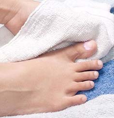 Close-up of clean foot being dried with towel.