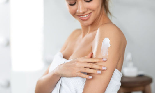women applying dry skin cream on her shoulder 